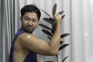 asiático hermoso hombre demostración vacunado brazo, conseguir vacunado a proteger en contra covid-19, antivirus corona virus concepto foto