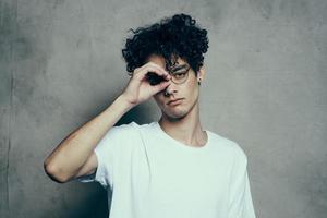 guy in white t-shirt gesturing with hand curly hair emotions Studio photo