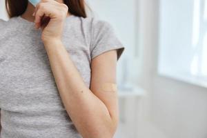 woman with plaster on her arm vaccination treatment photo