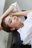 Women lying at home on the couch portrait with a short haircut in a white shirt, smile, depression in teenagers, home holiday photo