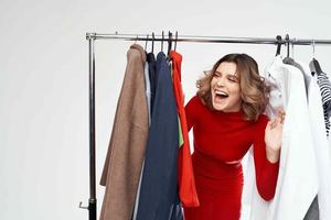 beautiful woman in a red jacket near the wardrobe retail isolated background photo