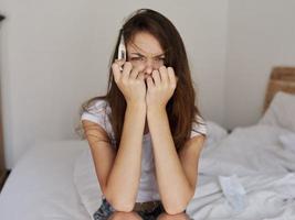 woman with a thermometer in her hands sitting on the bed emotion disorder photo