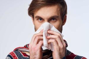 sick man with a handkerchief health problem flu symptoms light background photo