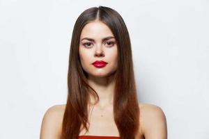 Woman with bare shoulders in an orange dress red lips photo