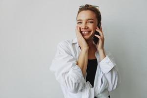 Adolescente niña sonriente y riendo hablando en el teléfono, vídeo llamar, chateando en línea foto