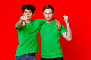 dos alegre amigos abrazo verde camisetas emociones comunicación rojo antecedentes foto