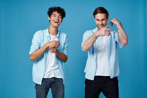 curly guy in a blue shirt and a blond man on a blue background communication friends fun photo