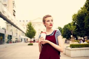 short haired woman outdoors fashion posing glass with drink photo