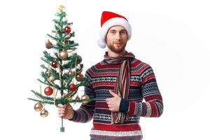 Cheerful man with a tree in his hands ornaments holiday fun isolated background photo