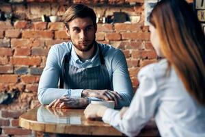 the waiter next to the client brings coffee service Professional photo