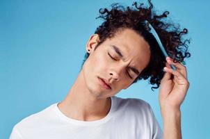 curly guy with a comb hair lifestyle blue background photo