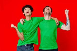 funny friends green t-shirts hugs emotions joy red background photo