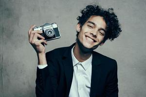 guy holding a camera in his hand retro classic suit curly model man photo