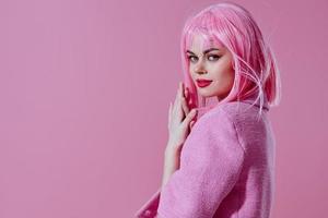 Beautiful fashionable girl pink jacket holding hair cosmetics pink background unaltered photo