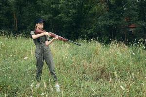Military woman with a gun in hand hunting travel lifestyle green leaves photo