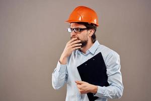 emotional worker man in orange paint documents service construction beige background photo