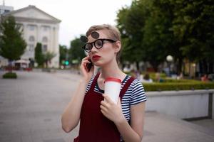 woman on the street talking on the phone wearing glasses glass with drink fashion photo