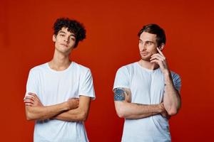 two friends in white t-shirts construction teams he emotions red background photo