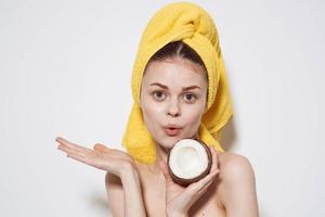 cheerful woman behind an animal with a towel on her head with a coconut in her hands exotic fruits natural cosmetics photo