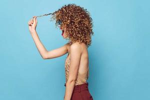 Charming model fun curly hair side view blue background photo