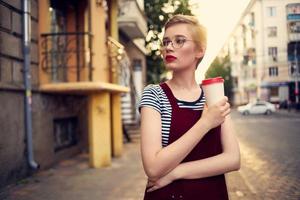 cheerful woman with a cup of drink outdoors relaxing photo