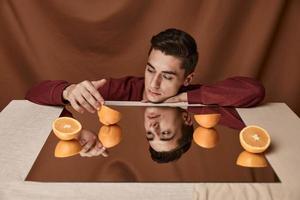 Man with oranges on the mirror and brunette fabric background model suit shirt photo