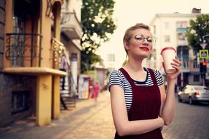 corto peludo mujer vistiendo lentes al aire libre caminar ocio bebida taza foto