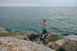 mujer naturaleza rocas costa paisaje Oceano relajación concepto foto