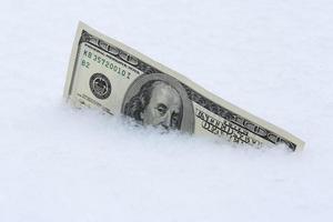 one hundred dollars banknote in snow photo