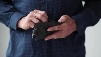 The hands of an adult man take 150 Russian rubles from an old wallet and show an empty wallet video