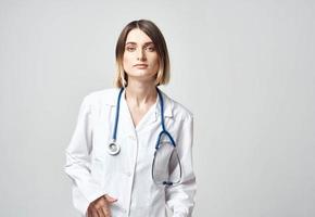 Professional doctor woman with blue stethoscope and white medical gown photo