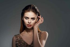 cheerful woman in a golden dress jewelry earrings fashion glamor photo