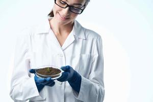 alegre mujer en blanco Saco estudiante Ciencias biotecnología plantas foto