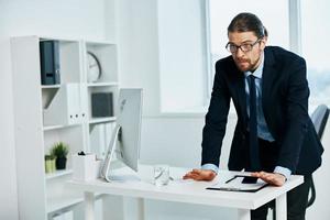 The man in a suit in the office gestures with his hands boss photo