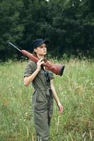 militar mujer pistola en hombro caza estilo de vida verde hojas foto