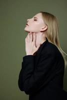 Stylish fashionable charming girl posing in profile looking to the side on a green olive background in the studio. Cool banner for brands photo