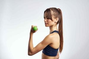 athletic brunette with dumbbells in hands workout cropped view fitness photo