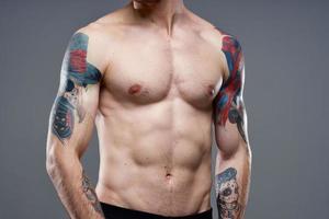 deportivo hombre con bombeado arriba abdominales recortado ver de tatuaje en brazos de cerca foto