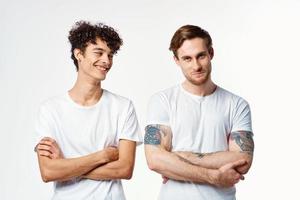 two men in white t-shirts stand side by side cropped view studio friendship photo