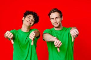 Cheerful friends in green t-shirts gesturing with hands isolated background photo