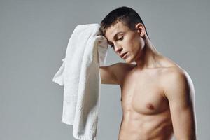 portrait of a sporty man with a pumped up body of a towel in his hands photo