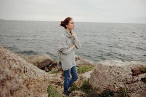 bonito mujer suéteres nublado mar admirativo naturaleza hembra relajante foto