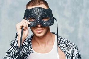 Cheerful man in shirt mask near face studio light background photo