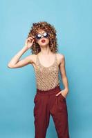 woman curly hair sunglasses attractive look red lips red pants photo