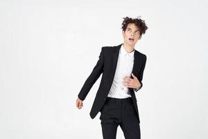 young guy in a classic suit on a light background curly hair portrait cropped view photo