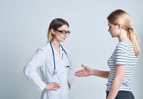 Woman doctor and patient shaking hands on a light background communicating medicine photo