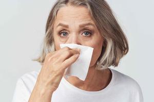 elderly woman runny nose handkerchief cold photo