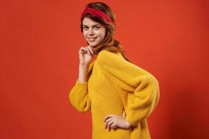 woman in yellow sweater with bandage on her head fashion red background studio photo