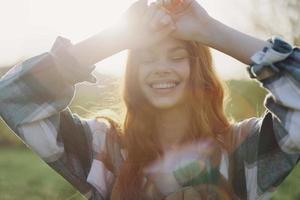 retrato de un mujer con un hermosa sonrisa y Derecho dientes en un verano día en el puesta de sol con volador Rizado pelo foto