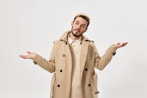 man gesturing with his hands fashion beige coat modern style studio photo